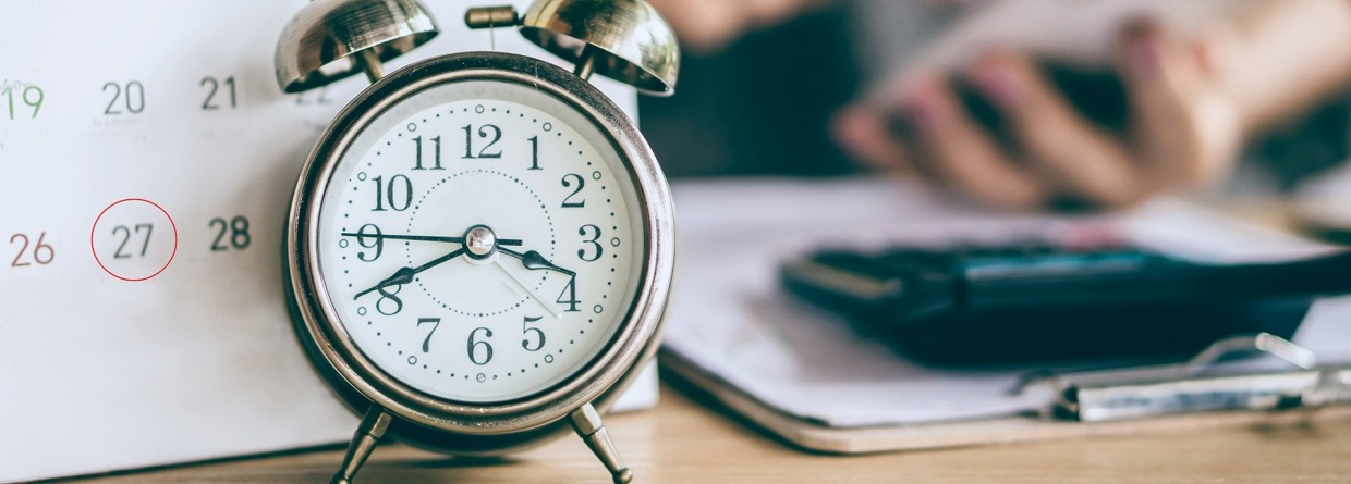 datum kalender en wekker met zakelijke vrouw hand berekenen